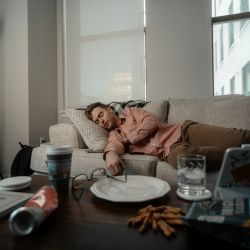a woman laying on a couch with a plate of food